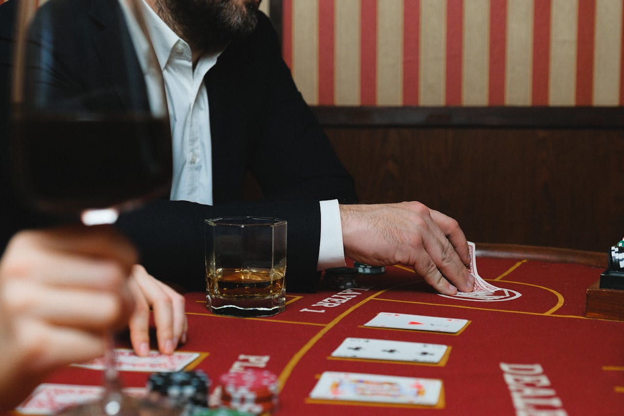 Elegant casino scene with playing cards, poker chips, and beverages on a table.